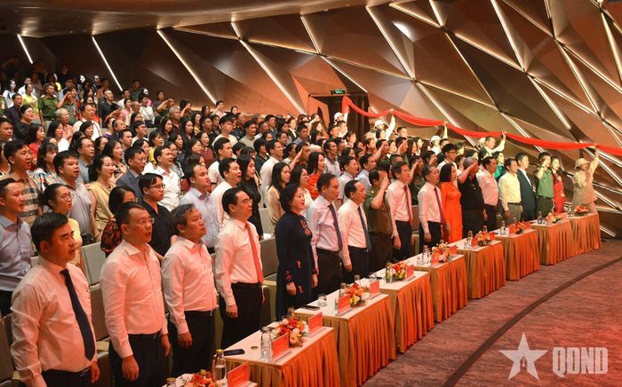Các đại biểu và khán giả thực hiện nghi thức hát Quốc ca.