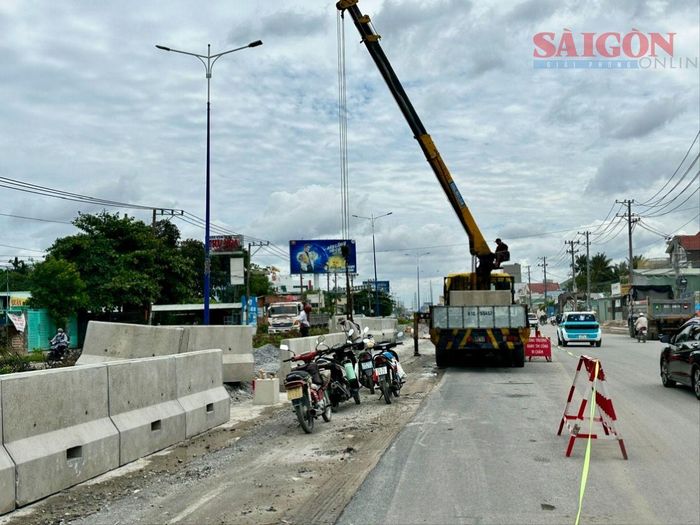 Chiều 30-8, các lực lượng triển khai lắp đặt dải phân cách cứng tại dự án mở rộng quốc lộ 13. Ảnh: XUÂN TRUNG