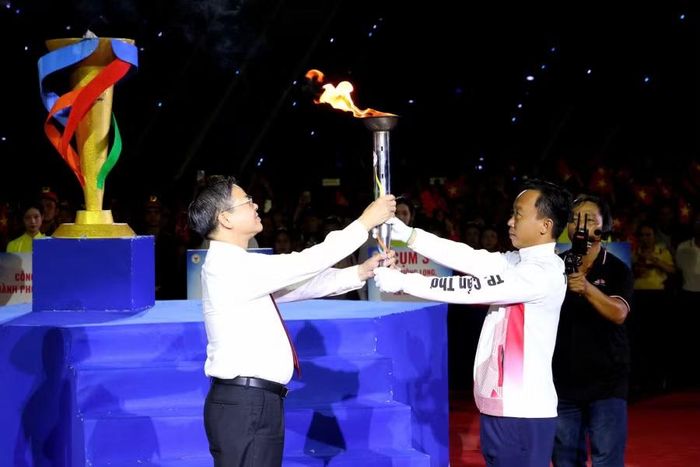 Ông Trương Cảnh Tuyên, Chủ tịch UBND TP Cần Thơ, tiếp nhận ngọn đuốc truyền thống từ đoàn VĐV tiêu biểu.