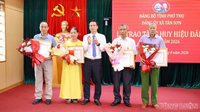 Chủ tịch UBND xã Tân Sơn Trần Tấn Giang trao Huy hiệu đảng cho các đảng viên - Ảnh: Phùng Thọ.