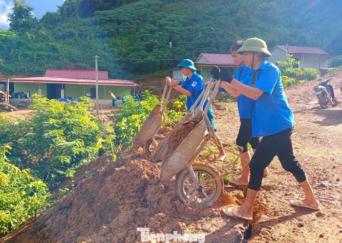  Trong màu áo xanh, các đoàn viên thoăn thoắt đẩy xe rùa chất đầy đất đá ra khỏi hiện trường. 
