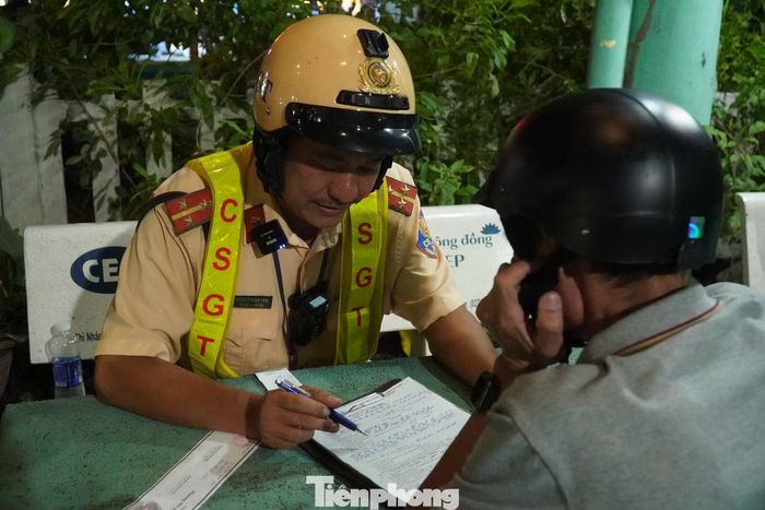 CSGT giải thích quy định, vận động người vi phạm chấp hành việc lập biên bản và tạm giữ phương tiện. Ảnh: Nguyễn Tiến