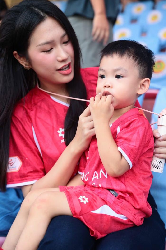 Doãn Hải My cùng con trai trên khán đài. Con trai 2 tuổi thường được mẹ đưa đến sân bóng để cổ vũ Đoàn Văn Hậu.