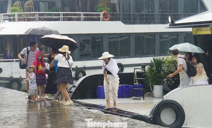Khoảng 15h, bất ngờ xuất hiện cơn mưa kéo dài trong 10 phút. Nhiều du khách vội vã rời xe khách vào bến tàu.