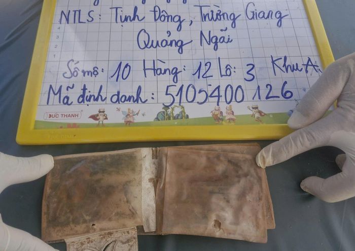 Chiếc ví da có tên "Trần Văn Thanh, quê quán Quảng Nam" trong mộ liệt sĩ. Ảnh: T.Duy