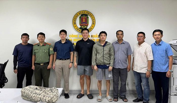 Lực lượng công an bàn giao 2 đối tượng Bang Giseong và Han Joohee cho phía Hàn Quốc (quần cộc, đứng giữa). Ảnh: CACC