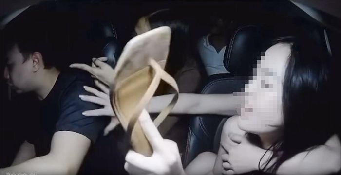 Một người phụ nữ cầm dép giơ về phía tài xế. Ảnh cắt từ clip