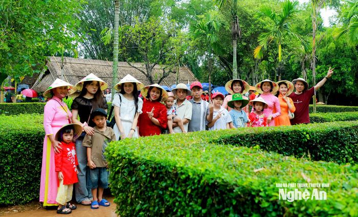 Một đoàn du khách chụp ảnh lưu niệm tại quê ngoại Bác Hồ. Ảnh: Thành Duy