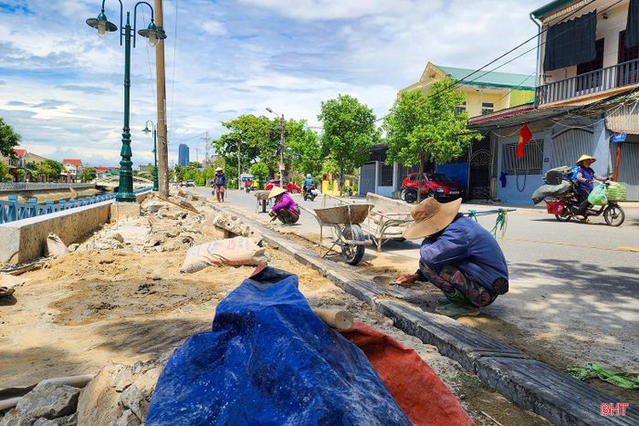 Công nhân thi công những hạng mục cuối cùng trên tuyến đường ven sông dài hơn 2,4 km. Theo thiết kế, khu vực này được chỉnh trang đồng bộ, kết hợp giữa hạ tầng thoát nước và không gian công cộng.