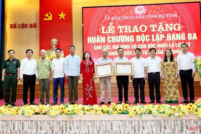 Các đại biểu tỉnh và địa phương chụp ảnh lưu niệm cùng thân nhân các gia đình được trao tặng Huân chương.