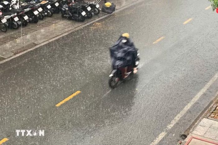 Người dân Thành phố Hồ Chí Minh đi trong cơn mưa. (Ảnh: Hồng Đạt /TTXVN)