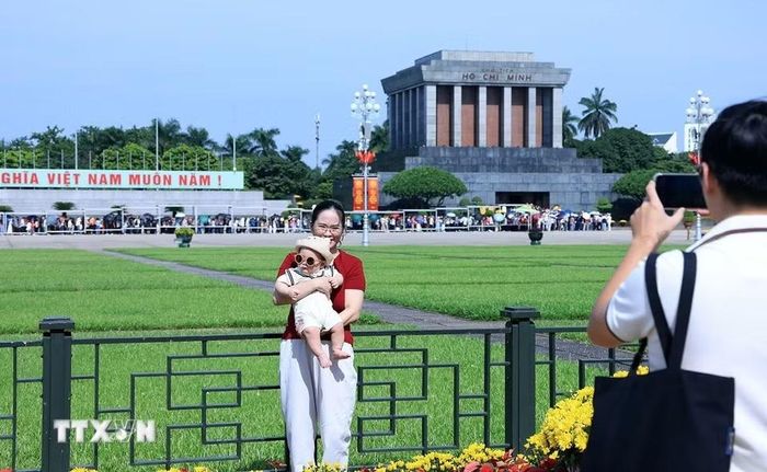 Một em bé được gia đình đưa đi chơi trong ngày nghỉ lễ. (Ảnh: Tuấn Anh/TTXVN)