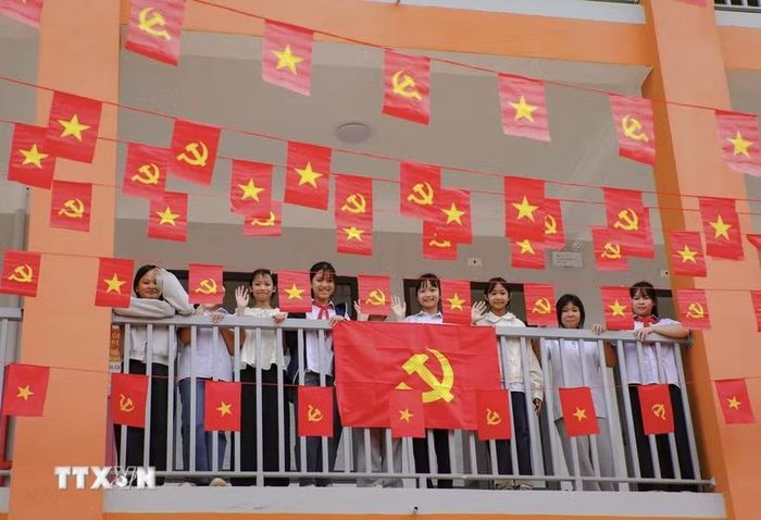 Học sinh Trường Phổ thông nội trú Tiểu học và THCS Sam Mứn tươi vui bên những lá cờ Đảng, cờ Tổ quốc được trang trí trên hành lang. (Ảnh: Xuân Tư/TTXVN)