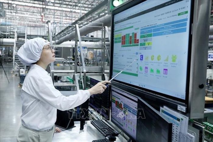 Công nhân Nhà máy Bông Sen (Tập đoàn Nestlé Việt Nam) đang vận hành dây chuyền sản xuất bằng bảng điều kiển tự động. Ảnh: Mạnh Khánh/TTXVN