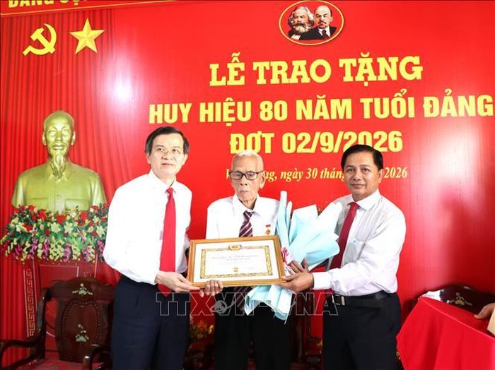 Đoàn công tác trao Huy hiệu 80 năm tuổi Đảng và hoa chúc mừng đảng viên Huỳnh Long Tòa, xã Cầu Ngang.