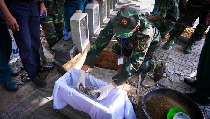 Cán bộ, chiến sĩ Đội K71 cẩn trọng ấy mẫu sinh phẩm hài cốt liệt sĩ tại Nghĩa trang liệt sĩ Dương Minh Châu, Tây Ninh.