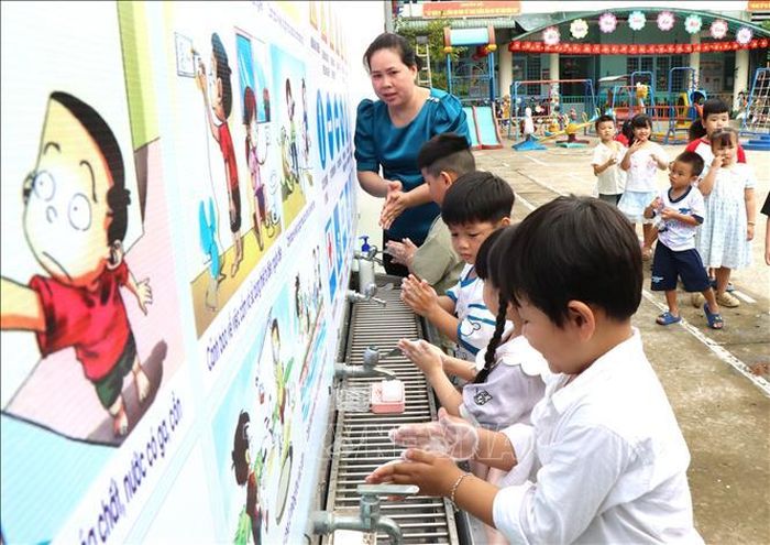 Giáo viên Trường Mầm non Măng Non (phường Long Châu, tỉnh Vĩnh Long) hướng dẫn học sinh thực hành các bước rửa tay trong ngày đầu đến làm quen với lớp học.