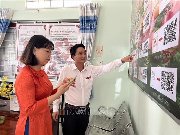 Chị Nguyễn Thị Đăng Khoa đến giải quyết thủ tục hành chính tại Trung tâm Phục vụ hành chính công xã Bình Hiệp, dành thời gian tìm hiểu thông tin về Chủ tịch Hồ Chí Minh.