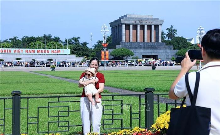 Một em bé được gia đình đưa đi chơi trong ngày nghỉ lễ. Ảnh: Tuấn Anh/TTXVN