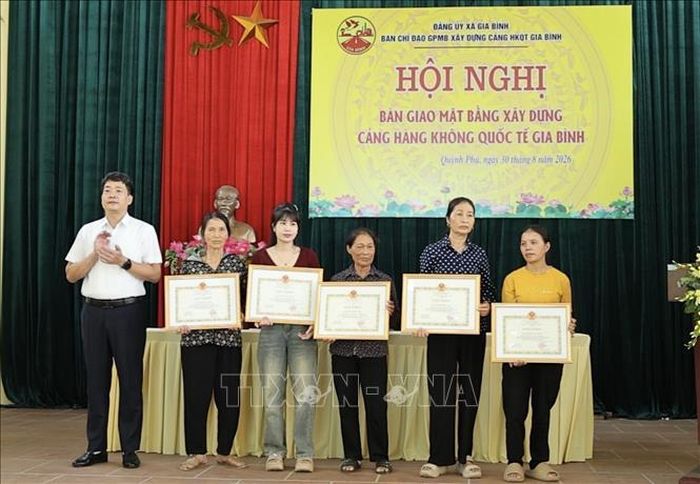 Xã Gia Bình khen thưởng các gia đình có thành tích xuất sắc trong bàn giao mặt bằng. Ảnh: Thái Hùng/TTXVN