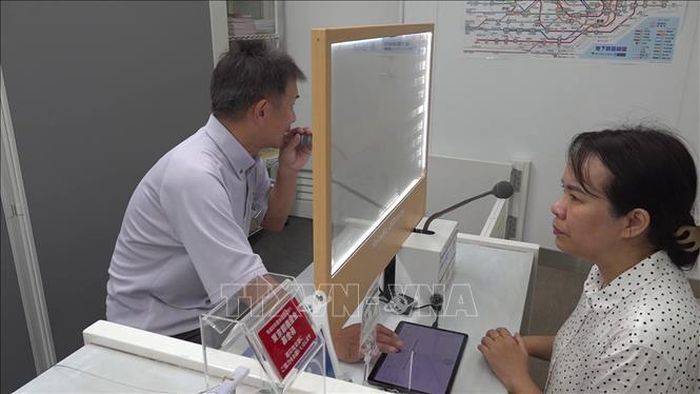 Nhân viên nhà ga đang trả lời câu hỏi của phóng viên hiển thị trên màn hình phiên dịch. Ảnh: Xuân Giao/TTXVN