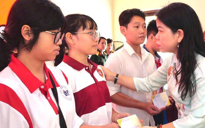 Bà Nguyễn Thị Ngọc Xuân (bìa phải), Phó Chủ tịch Ủy ban MTTQVN TPHCM, Chủ tịch Hội LHPN TPHCM, trao quà cho các em tại chương trình.