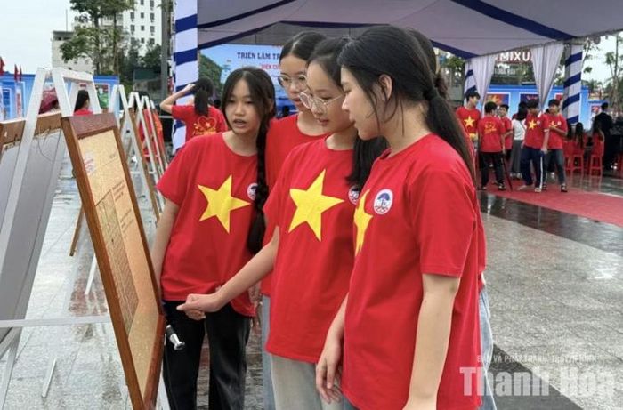 Các em học sinh hào hứng xem những tranh cổ động và ảnh tư liệu "Biên cương vững bền - Biển đảo thiêng liêng".