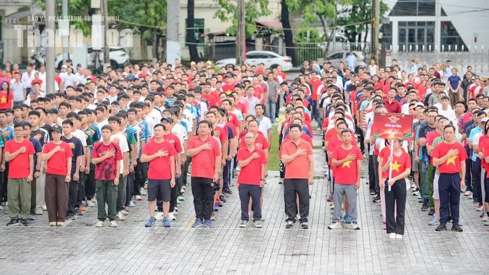 Giữa không gian rộng lớn, tiếng loa từ sân khấu vọng xuống hòa cùng tiếng bước chân, tiếng trò chuyện và những lời chào hỏi. Không khí ngày hội dần hình thành từ những chuyển động bình dị ấy.
