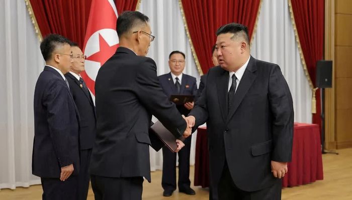 Nhà lãnh đạo Triều Tiên Kim Jong-un (phải) gặp gỡ đội ngũ các nhà khoa học, chuyên gia nghiên cứu và quan chức từ các viện nghiên cứu quốc phòng lớn, ngày 29/8. Ảnh: Yonhap.
