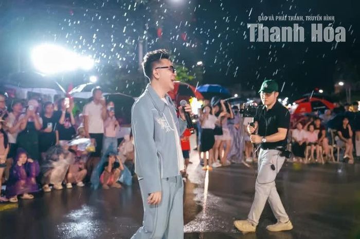 Dưới làn mưa lất phất, ca sĩ Minh Vương hát và giao lưu cùng khán giả Hải Tiến.