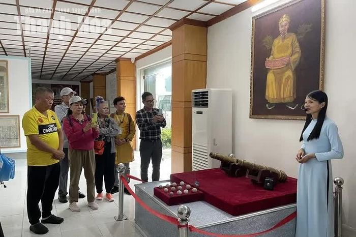 Hướng dẫn viên Vũ Thị Lanh giới thiệu những hiện vật tại phòng trưng bày Di sản Văn hóa Thế giới Thành nhà Hồ.