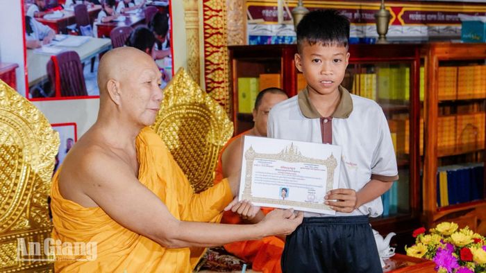 Hòa thượng Chau Sơn Hy, Phó Chủ tịch Hội Đoàn kết sư sãi yêu nước tỉnh An Giang trao giấy chứng nhận hoàn thành lớp 2 cho em Chau Vi Răk.