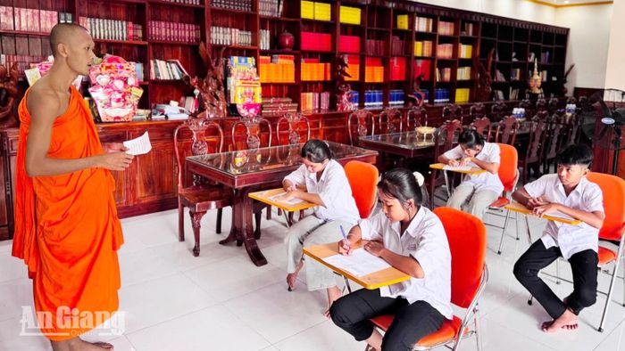 Đại đức Chau Đô Rone, giáo viên dạy chữ Khmer, hướng dẫn học sinh thực hiện phần kiểm tra viết tại chùa Chi Kà Êng Dưới, xã Tri Tôn.