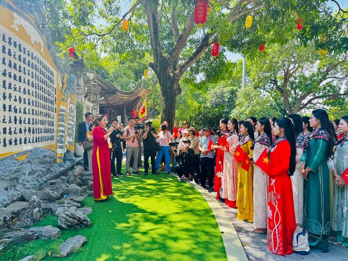  Thí sinh Hoa hậu Việt Nam 2026 lắng nghe hướng dẫn viên giới thiệu về lịch sử Đền Đô. 