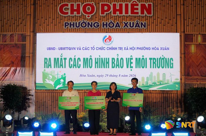 Lãnh đạo phường Hòa Xuân trao bảng tượng trưng ra mắt các mô hình bảo vệ môi trường cho các đơn vị. Ảnh: TÂM ĐAN