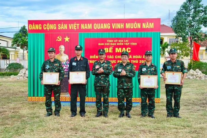  Ban Chỉ đạo diễn tập tỉnh cùng lãnh đạo xã Hoài Ân tặng quà động viên lực lượng tham gia thực binh và khen thưởng các tập thể có thành tích xuất sắc trong thực hiện nhiệm vụ diễn tập. Ảnh: T.Q 