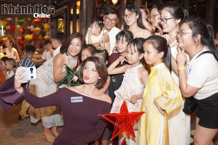 Người đẹp Mary Samantha Anna Sickler (Mỹ) chụp ảnh lưu niệm với du khách và các em nhỏ.
