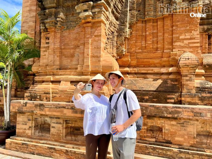 Hai du khách quốc tế chụp ảnh lưu niệm tại Di tích quốc gia đặc biệt Tháp Bà Pô Nagar.