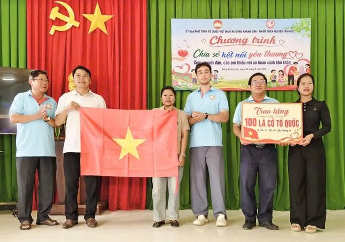 Đại diện nhóm Tâm Đức Khánh Hòa tặng cờ Tổ quốc cho các gia đình.
