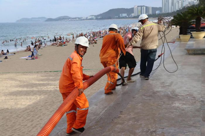 Công nhân ngành điện kéo dây cáp điện phục vụ sự kiện tại Quảng trường 2 tháng 4.