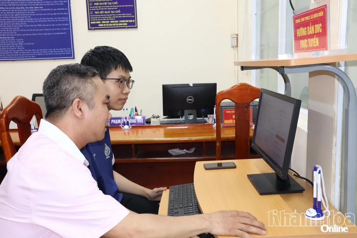 Cán bộ xã Diên Điền hướng dẫn người dân nộp hồ sơ trực tuyến.