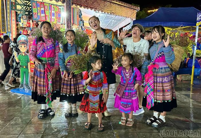 Du khách thích thú khi được gặp gỡ, check in cùng những em bé và người dân địa phương tại chợ đêm Bắc Hà.
