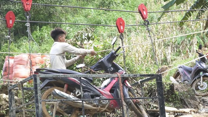Anh Giàng A Giàng đưa xe máy bằng cáp treo qua suối.