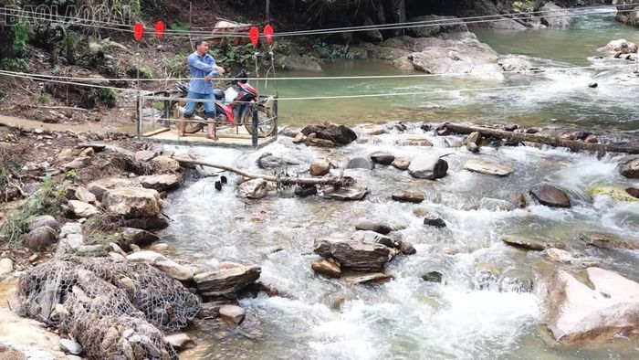 Bí thư Chi bộ thôn Tà Dông, Sùng A Cớ đưa xe máy qua cáp treo.