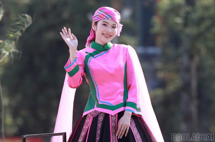 Người đẹp trên xe diễu hành mang âm hưởng dân tộc Giáy vẫy chào người dân, du khách hai bên đường.