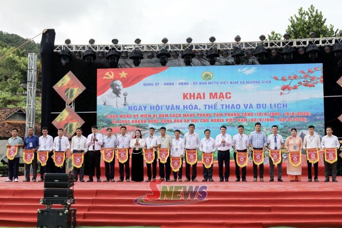 Đồng chí Đặng Ngọc Hậu, Phó Chủ tịch UBND tỉnh và lãnh đạo xã trao cờ lưu niệm cho các bản, đơn vị tham gia ngày hội.
