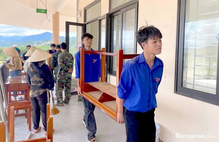 Đoàn viên thanh niên được huy động để hỗ trợ vận chuyển bàn ghế vào các phòng học.