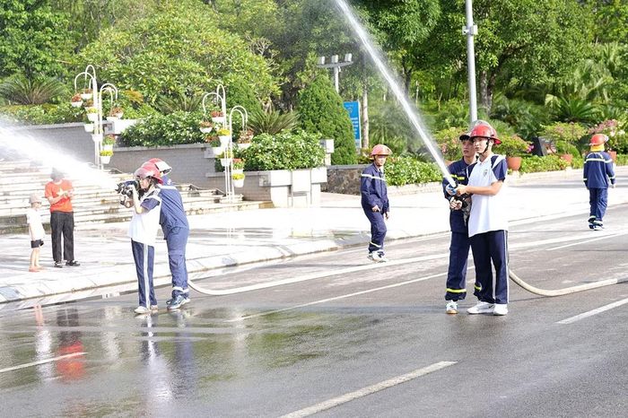 Dưới sự hướng dẫn của cán bộ Phòng Cảnh sát PCCC và CNCH, người dân thực hành phun nước chữa cháy.