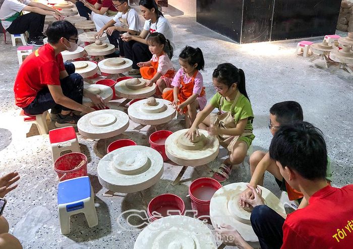 Trẻ nhỏ thích thú trải nghiệm làm gốm dưới sự hướng dẫn nhiệt tình của nhân viên Bảo tàng Gốm Bát Tràng.