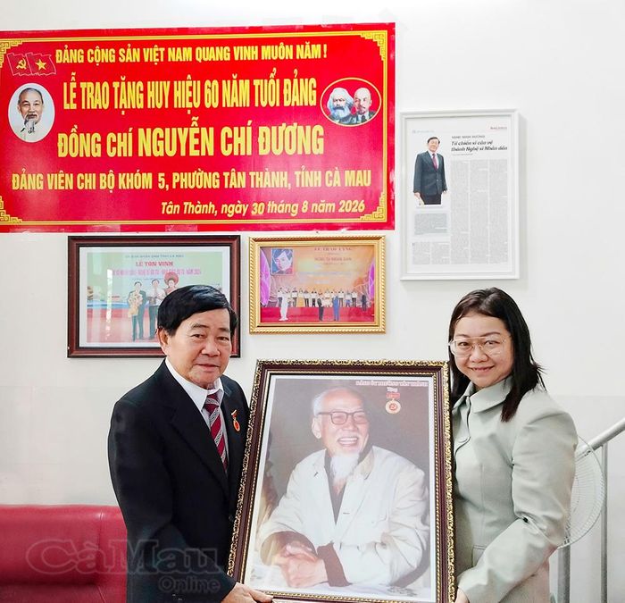 Đồng chí Mai Thị Thuỳ Trang, Phó Bí thư Thường trực Đảng uỷ phường Tân Thành, trao ảnh Chân dung Bác Hồ tặng NSND Minh Đương.